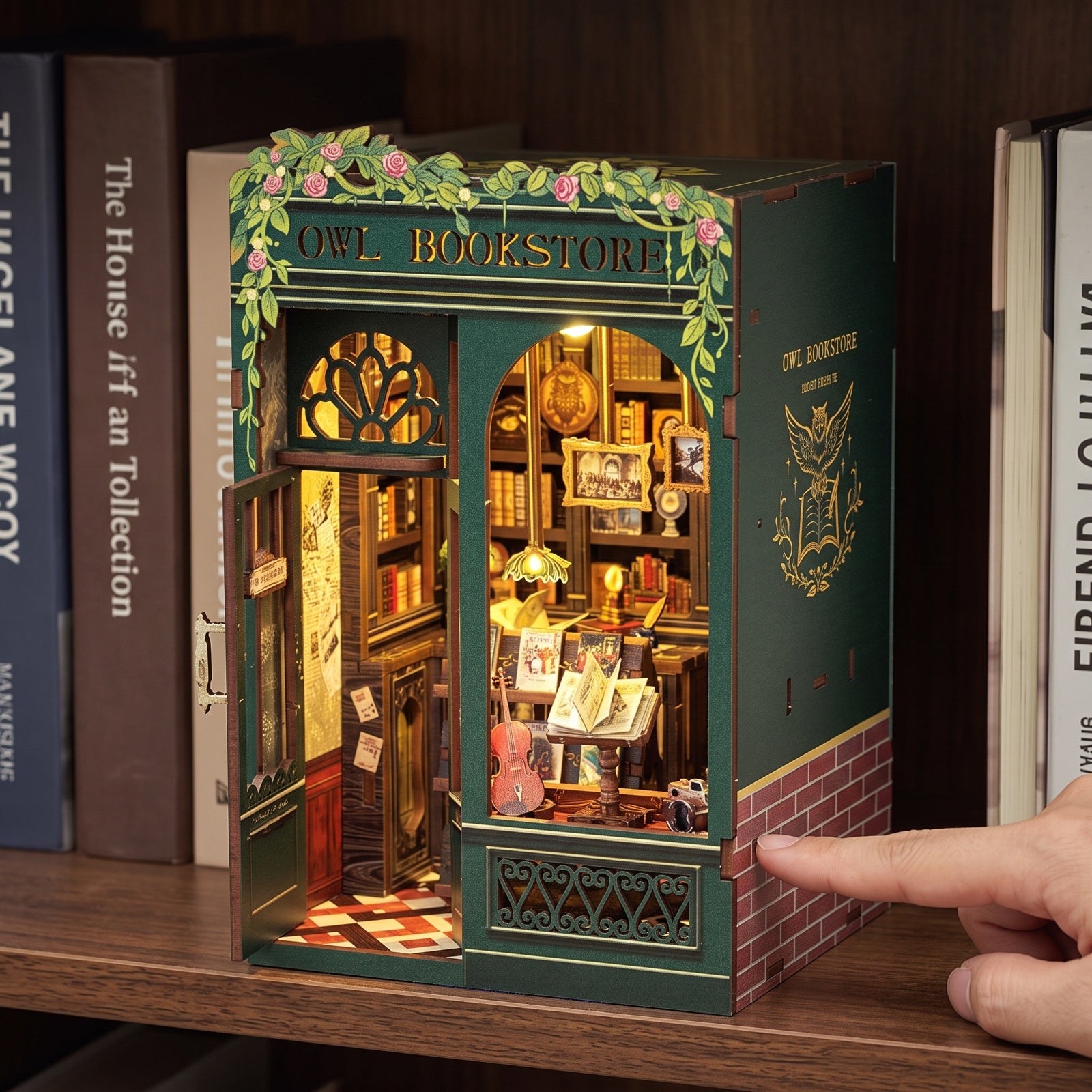 Close view of tiny books and shelves in the lit Owl book nook