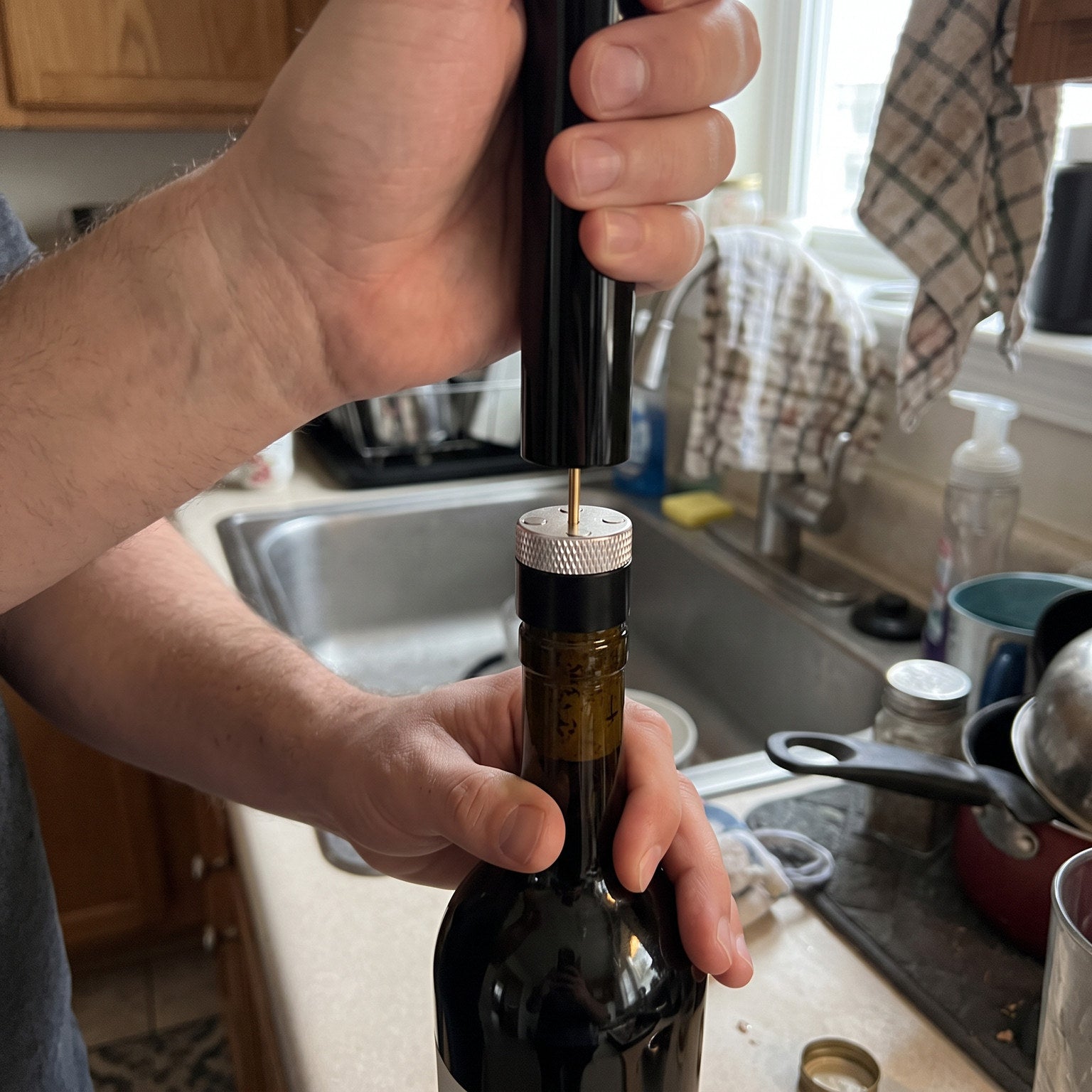 Hands holding the Silver Openvale opener and its parts